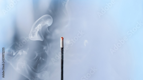incense smoke. smoldering piece of wood . incense sticks in blue lighting. aromatic smoke . photo