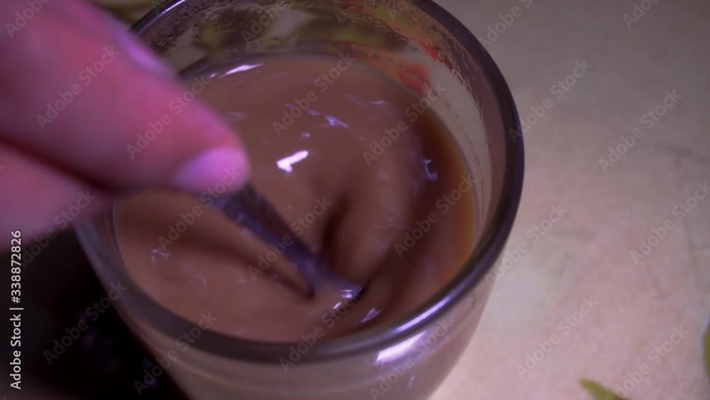 The person holding the spoon in the coffee mug The person holding the spoon in the coffee mug