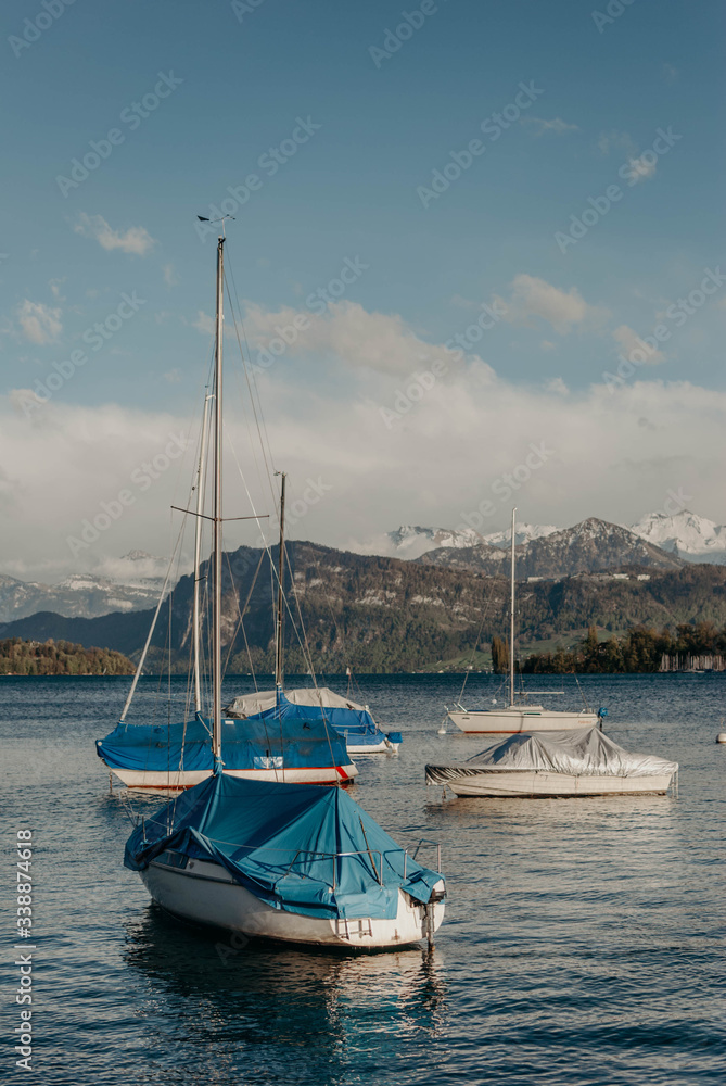 Swiss boat yachts floating in Lucerne lake near Alps mountains in the town of Luzern, Switzerland, Europe