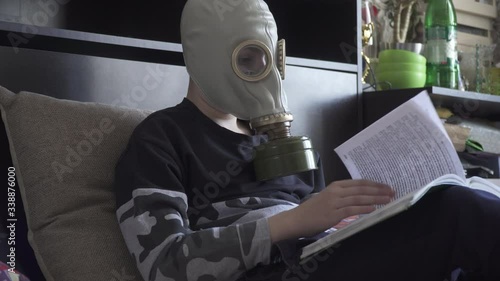 A boy in a gas mask from viruses reads a book