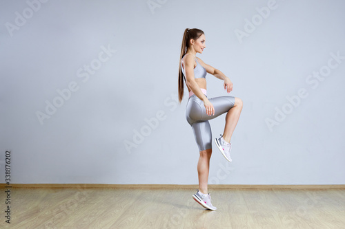 Fit woman doing cardio interval training in gym. Woman in sportswear is posing and jumping. Fitness and sport concept.