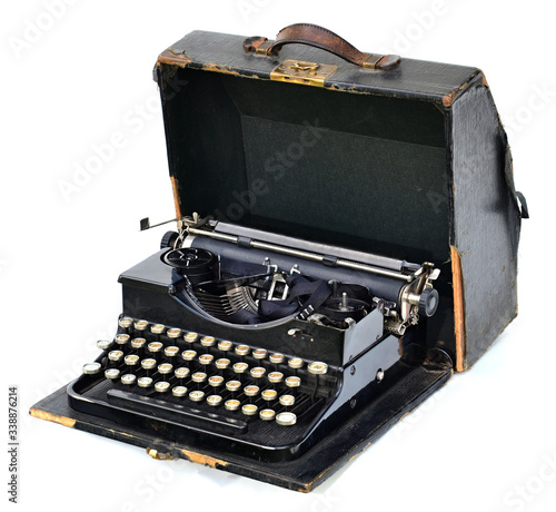 Old typewriter with black suitcase on white background.