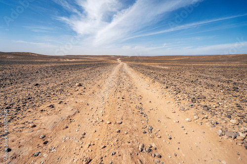 Dirt road through endless Sahara desert, Morocco, Africa