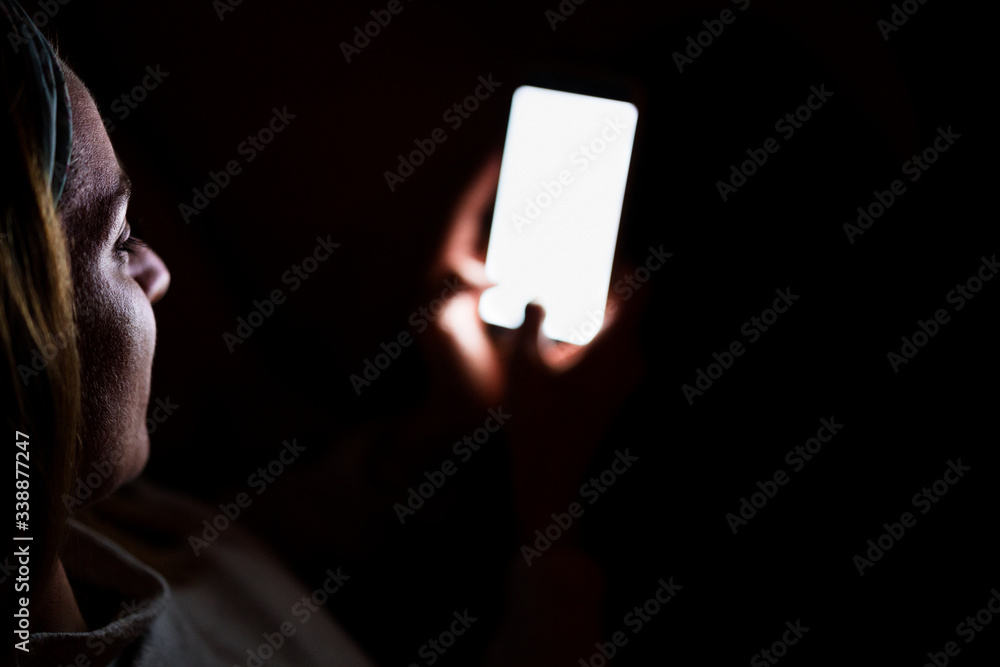 Naklejka premium young woman at home using mobile phone. Night time