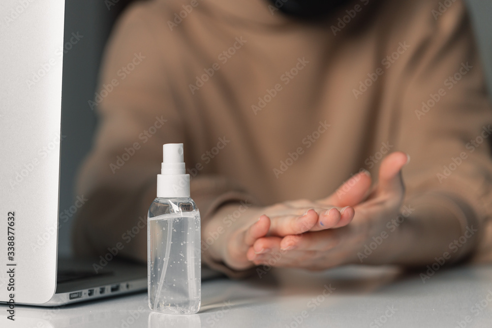 Man working from home during coronavirus quarantine. Cleaning her hands with sanitizer gel. Close up photo of sanitizer gel Man working from home during coronavirus quarantine. Cleaning her hands with sanitizer gel. Close up photo of sanitizer gel