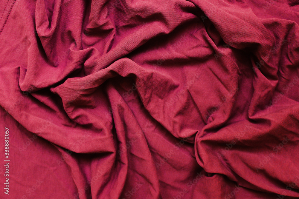 Crumpled dark red wavy fabric texture. Dark burgundy red cloth background. Wrinkled clothing detail, chewed up messy colorful fabric backdrop Crumpled dark red wavy fabric texture. Dark burgundy red cloth background. Wrinkled clothing detail, chewed up messy colorful fabric backdrop
