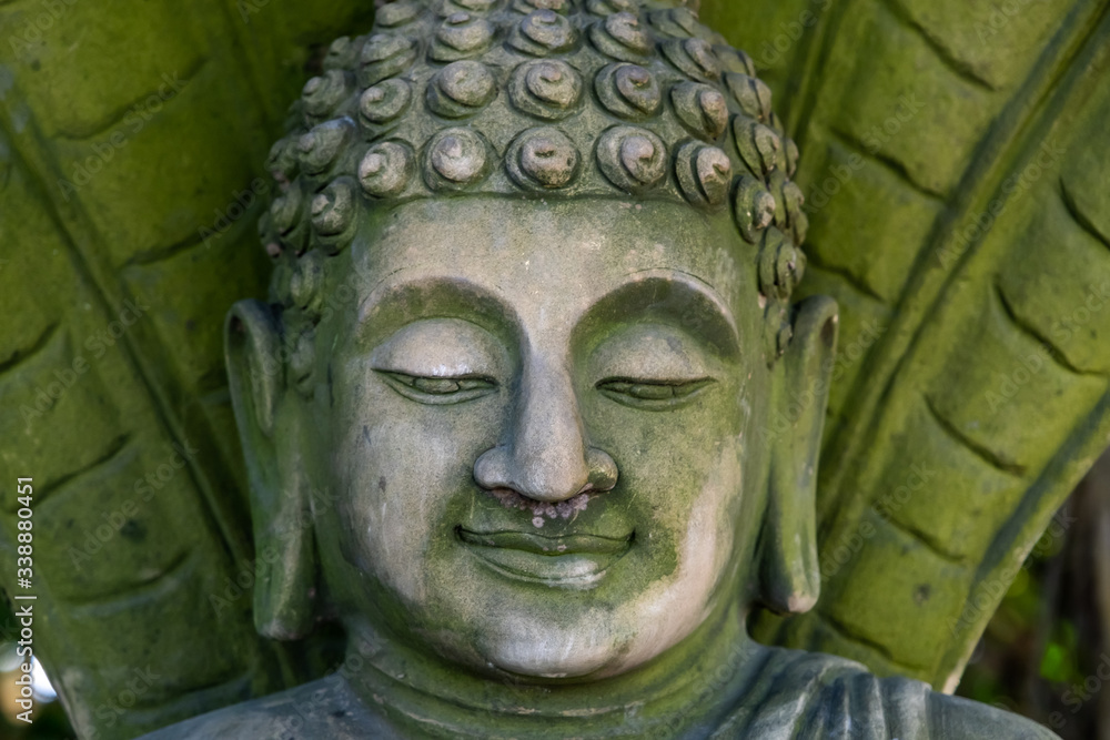Fototapeta premium Green stone Buddha face, closeup photo of face of Buddha