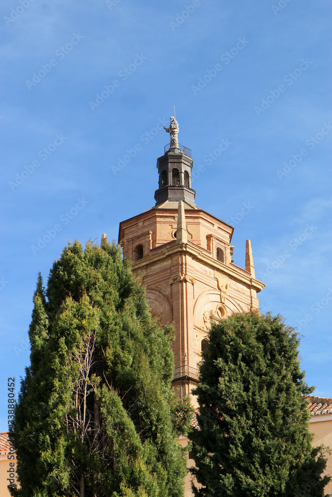 Bell tower of Guadix cathedral of the Incarnation, Granada, Spain surrounded by green trees