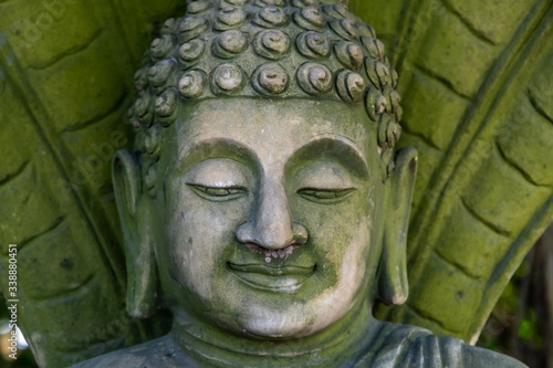 Green stone Buddha face, closeup photo of face of Buddha