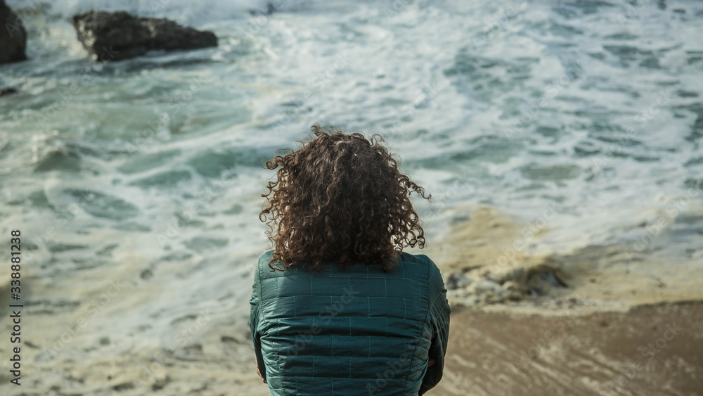Young Women sitting and reflecting at ocean waves Young Women sitting and reflecting at ocean waves