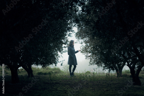Woman walking through forest in the fog