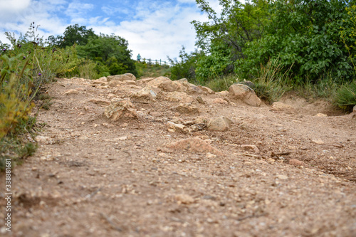 steep hiking path through the bushes. Rock passage in the mountain