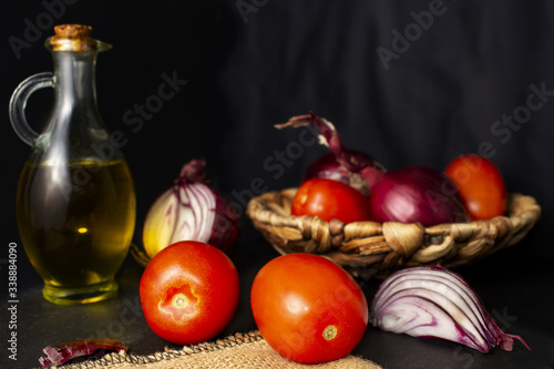 Still life of tomatoes, olive oil and purples onions