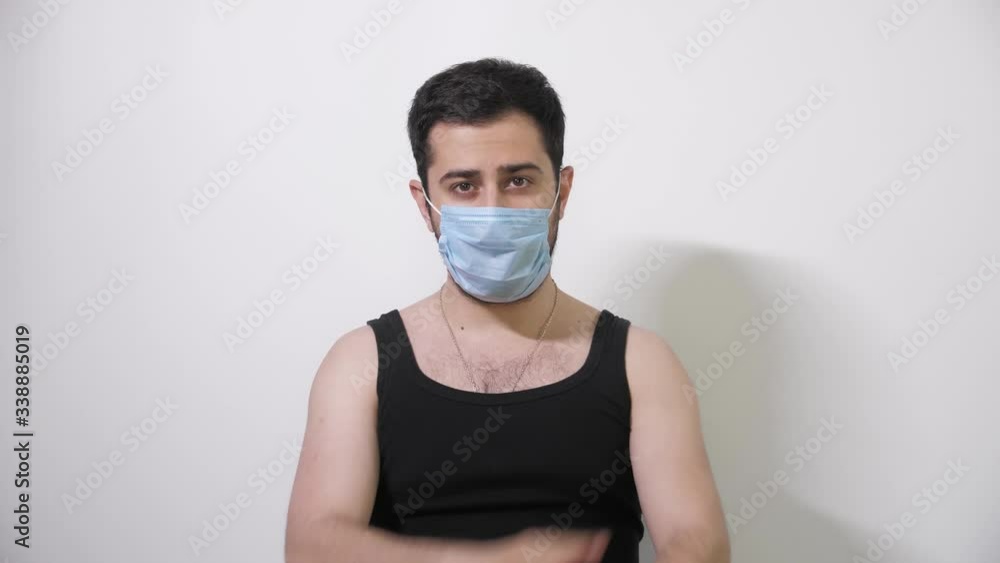 Caucasian man in medical mask makes an interesting move looks into camera Covid19 Coronavirus Caucasian man in medical mask makes an interesting move looks into camera Covid19 Coronavirus