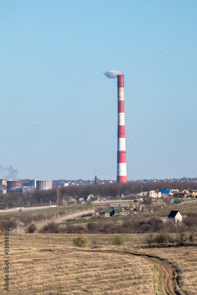 Energy heat power station pipe with red white stripes. Europe, Ukraine industrial clear sky landscape with air pollution smoke tower