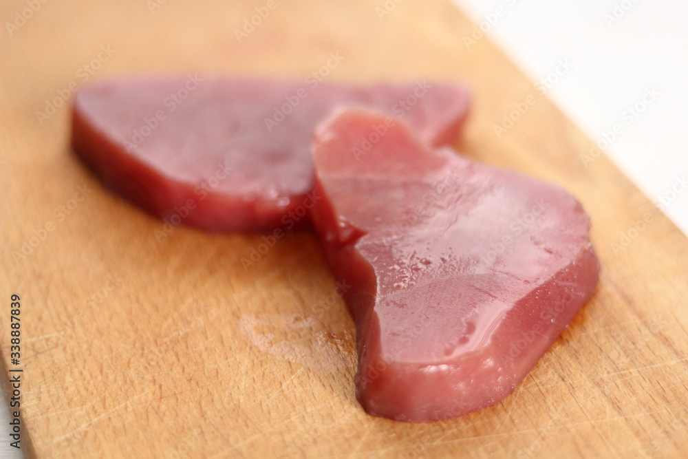 Raw tuna steak on wooden cutting board Raw tuna steak on wooden cutting board