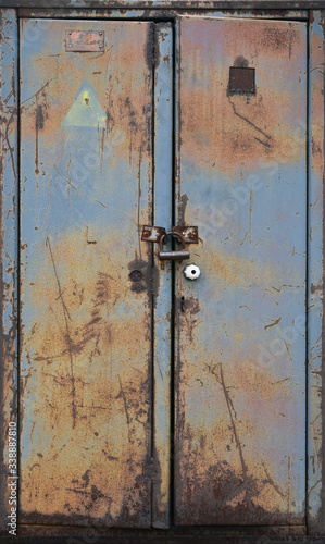 Old metal gray double door with peeling paint.