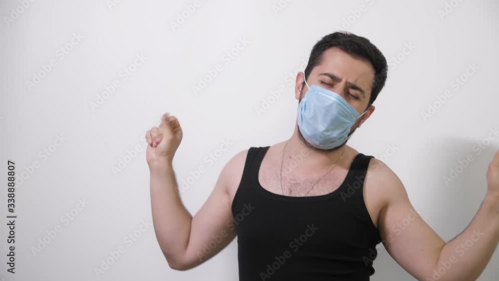 Caucasian man in a medical mask dancing fanny dance white background Covid19 Coronavirus Caucasian man in a medical mask dancing fanny dance white background Covid19 Coronavirus