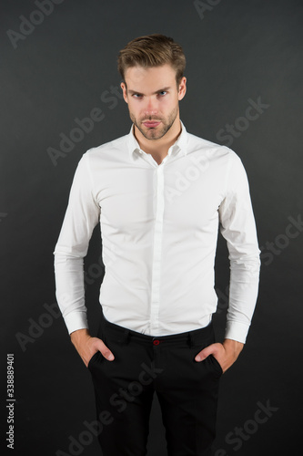 Wear it simple. White shirt and black pants. Serious man dark background. Fashion look of handsome guy. Fashion model in classic style. Fashion and style. Ready to go fashion wardrobe