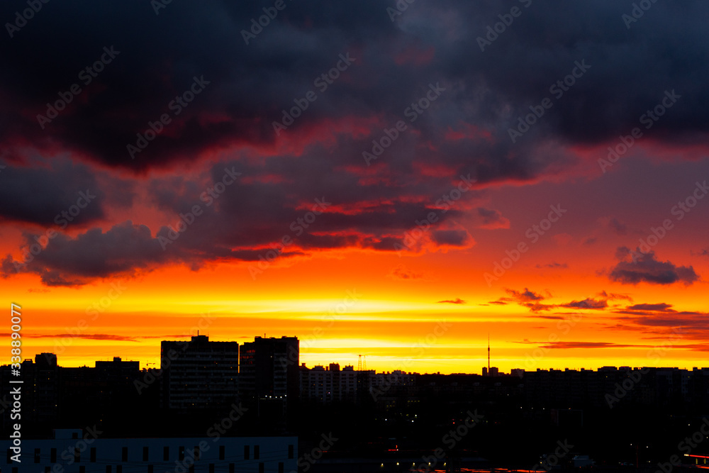 Colourful evening sky painted with red, orange, blue, grey, pink colours. and silhouettes of buildings