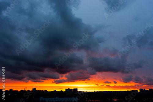Colourful evening sky painted with red, orange, blue, grey, pink colours. and silhouettes of buildings