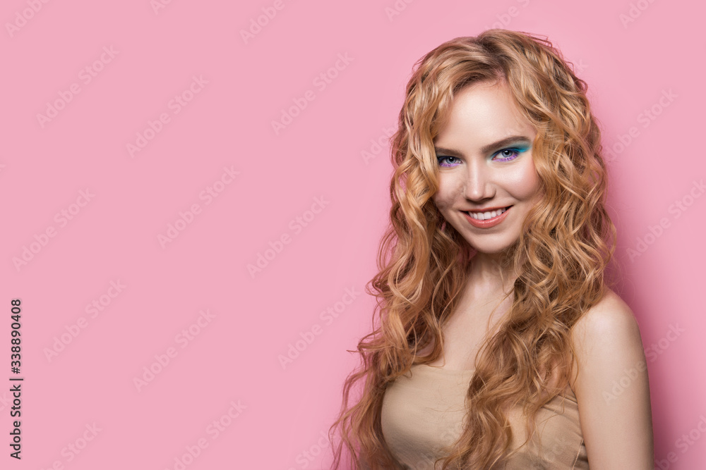 Smiling beautiful blonde woman with curly shiny hair on pink background. Wavy hairstyle, copy space for your text Smiling beautiful blonde woman with curly shiny hair on pink background. Wavy hairstyle, copy space for your text