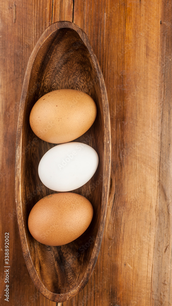 Easter holidays concept. Organic eggs in wooden bowl on wood background with copyspace. Copyspace, place for text and wording. Easter holidays concept. Organic eggs in wooden bowl on wood background with copyspace. Copyspace, place for text and wording.