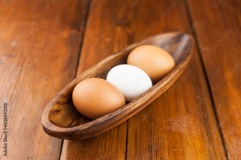 Easter holidays concept. Organic eggs in wooden bowl on wood background with copyspace. Copyspace, place for text and wording. Easter holidays concept. Organic eggs in wooden bowl on wood background with copyspace. Copyspace, place for text and wording.