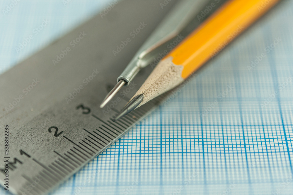 drawing compass, pencil, and ruler on graph paper background drawing compass, pencil, and ruler on graph paper background