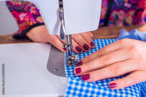 woman hand with dress at sewing machine