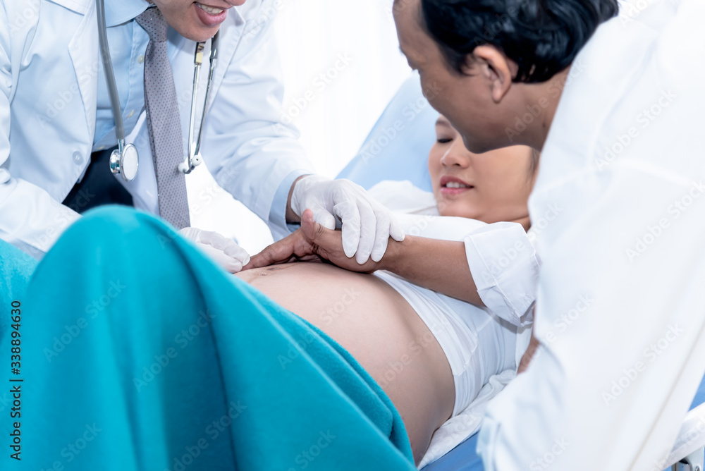 Doctor took the husband's hand To lay upon the womb of the wife Lying on the patient's bed to touch and sense the baby's movements That is in her stomach, to health care and family concept Doctor took the husband's hand To lay upon the womb of the wife Lying on the patient's bed to touch and sense the baby's movements That is in her stomach, to health care and family concept