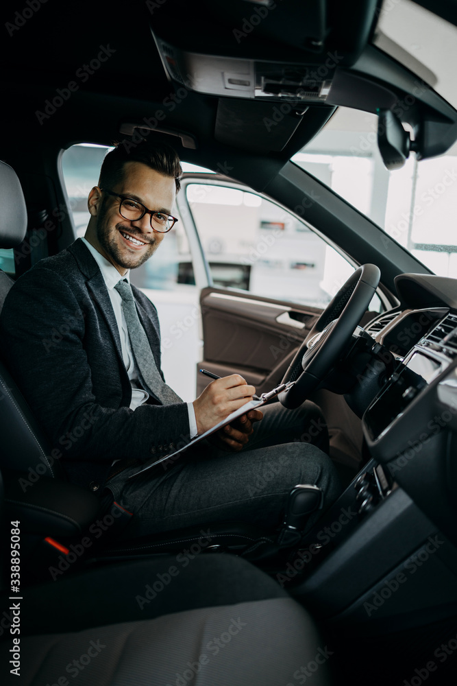 Car seller working in showroom and quality control checking of car details for the last time before buyer comes.