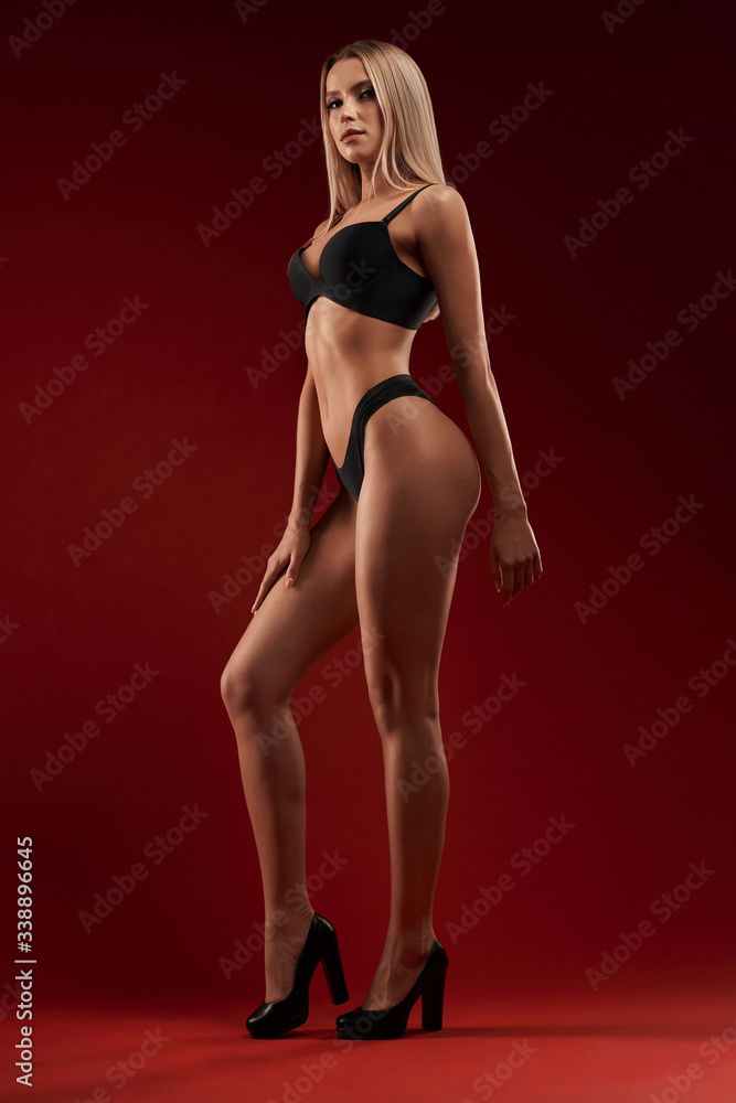 Sexy woman in lingerie isolated on red.