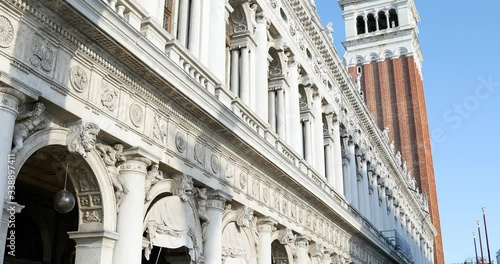 National Marciana library facade and San Marco bell tower tilt view, clear blue sky in Venice, Italy photo