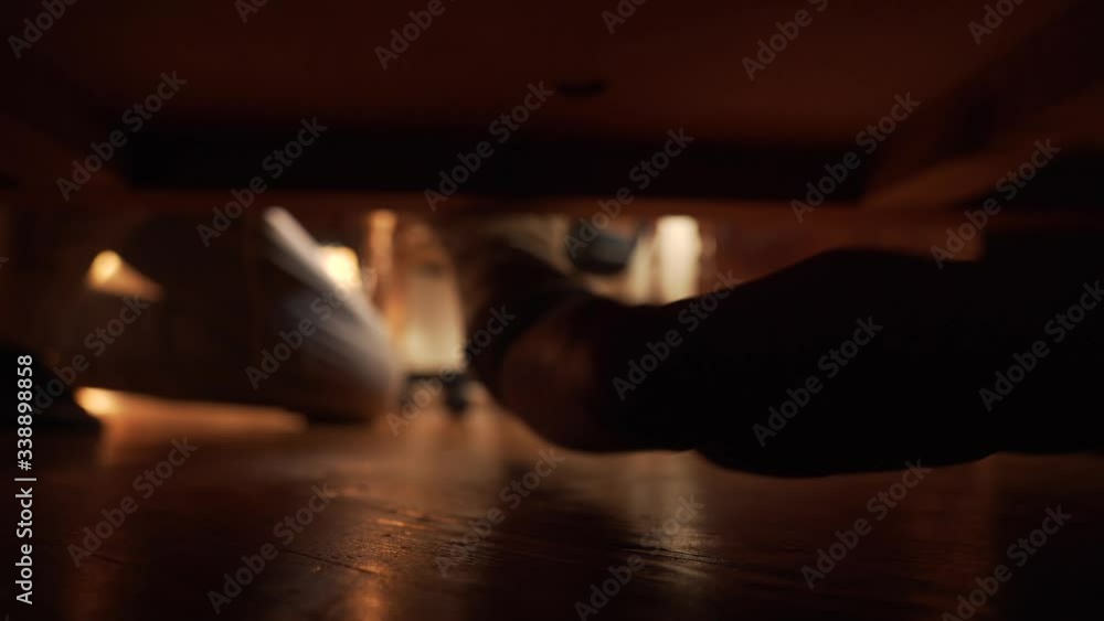 Man Looking For Something Under The Bed. The hand gropes for an object