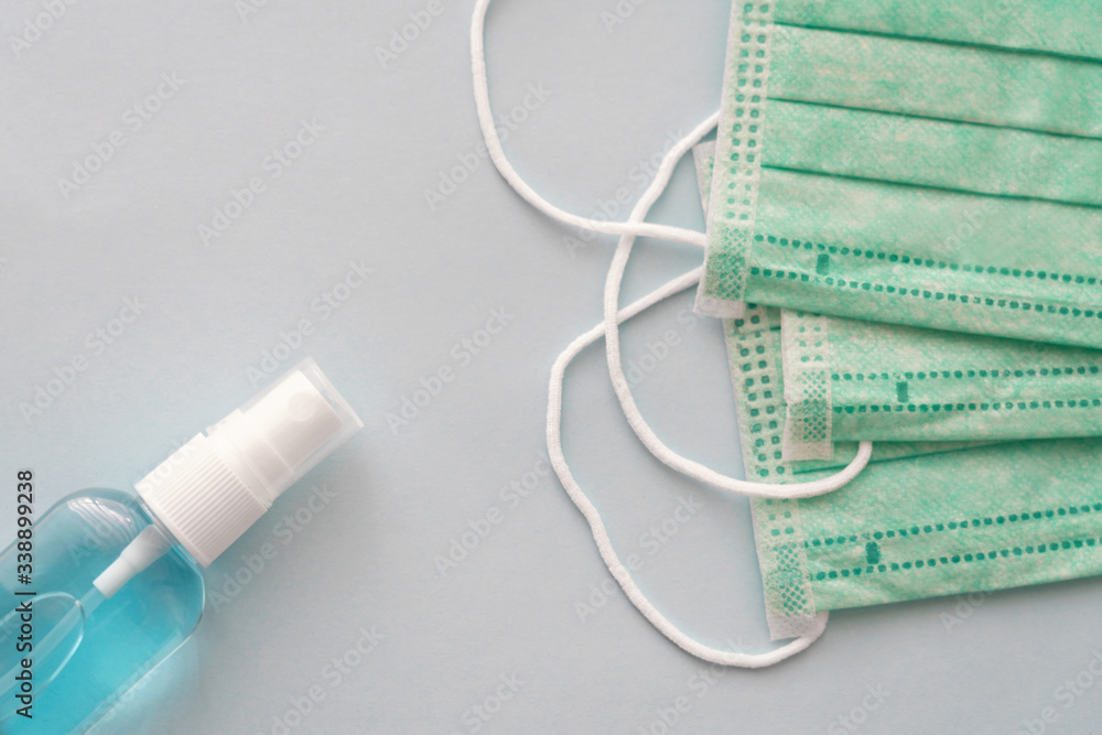 Hand sanitizer bottle and medical masks, anti-infective hygienic and health protection concept, Coronavirus Covid-19 protection