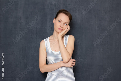 Portrait of thoughtful focused woman propping up head with hand