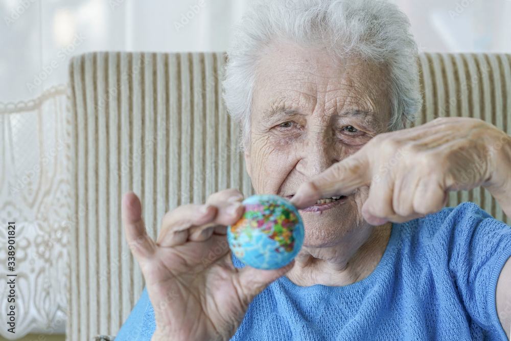 old woman showing small globe on her wrinkled hand old woman showing small globe on her wrinkled hand