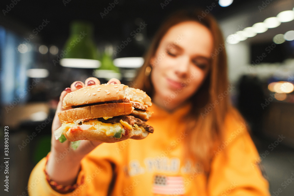 Φωτογραφία Closeup photo, big tasty burger in hands of attractive girl