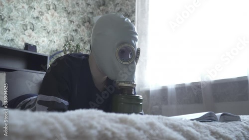 A boy in a gas mask from viruses reads a book