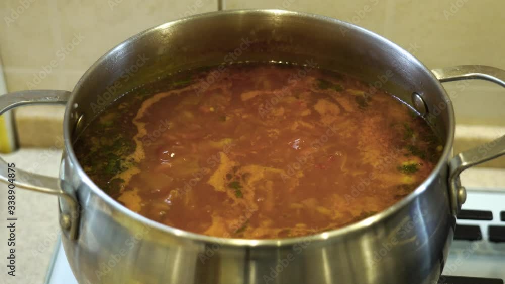 Medium shot. Vegetable soup, Ukrainian borsch is boiling in a large metal pan. Medium shot. Vegetable soup, Ukrainian borsch is boiling in a large metal pan.