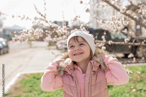Wallpaper Mural Little girl walks on a background of a blossoming tree in spring
 Torontodigital.ca