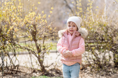 Little girl walks in nature in the spring park