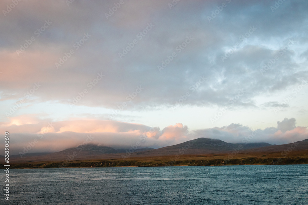 Dramatic panorama view on Isle of Jura coastline, from Isle of Skye, Scotland, sunset time, hills covered with cloudy sky