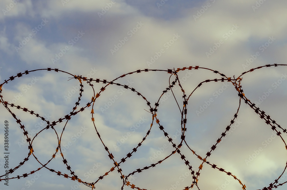 Barbed wire against the sky with clouds. The prohibition of air travel. Barbed wire against the sky with clouds. The prohibition of air travel.