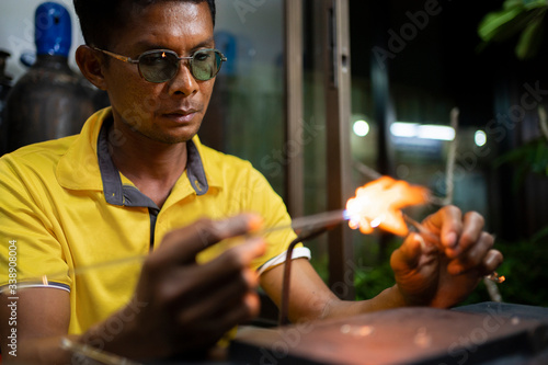 Senior man forming melting glass photo