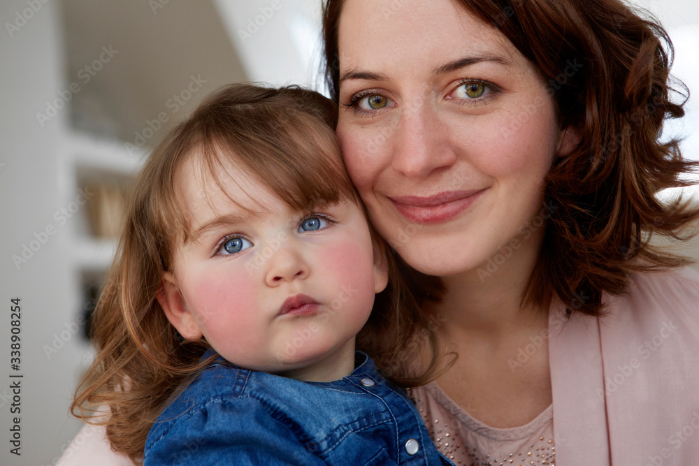 Portrait of happy young mother head to head with her little daughter Portrait of happy young mother head to head with her little daughter