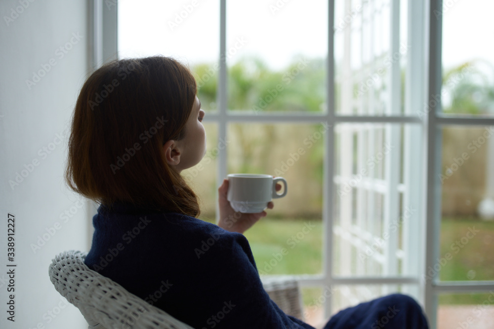 Woman at home near the window interior cup of coffee rest Woman at home near the window interior cup of coffee rest