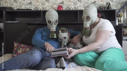 Family in gas masks from viruses watch photo album