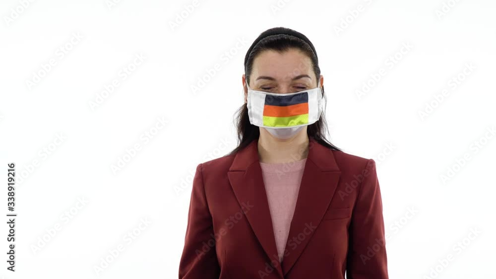 Virus and disease prevention concept. Pandemic and quarantine. A woman wears a protective medical mask with the image of the flag of Germany. Woman showing ring or OK gesture. Virus and disease prevention concept. Pandemic and quarantine. A woman wears a protective medical mask with the image of the flag of Germany. Woman showing ring or OK gesture.
